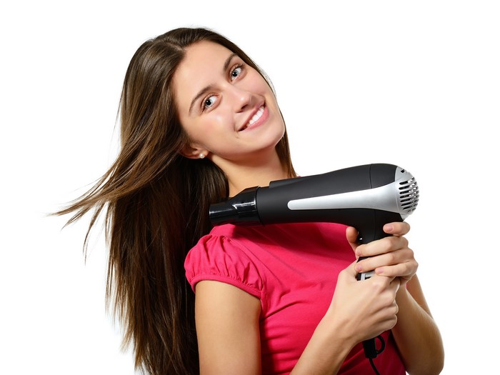Woman with brown hair holding a hair dryer