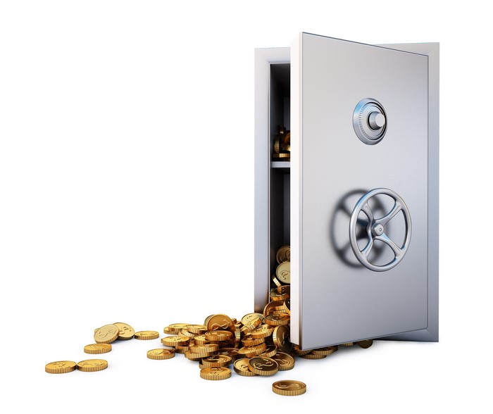 Open safe spilling gold coins on white background