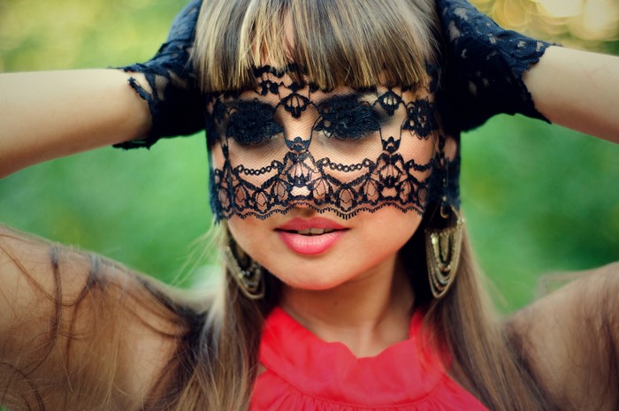 Woman wearing a black lace mask and red top