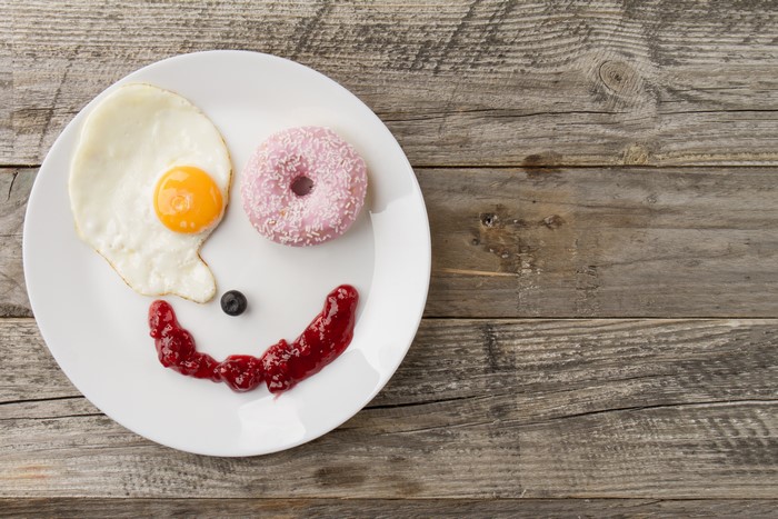 Fried egg and donut breakfast arranged as a smiley face