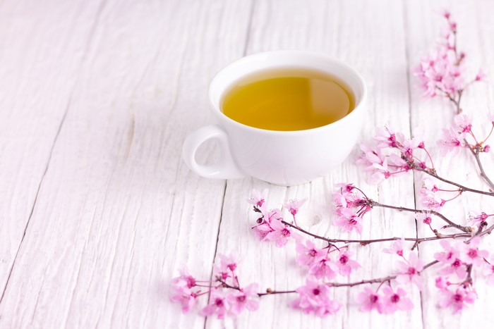 Cup of Tea with Sakura Branches on Wood Planks
