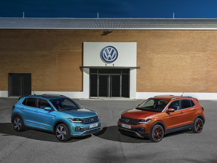 Two Volkswagen T-Cross cars in front of building