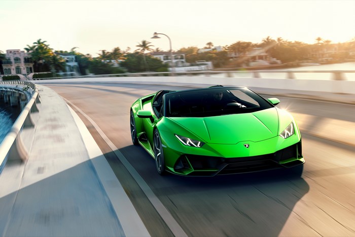 Green Lamborghini Spyder Evo Huracan driving on a road