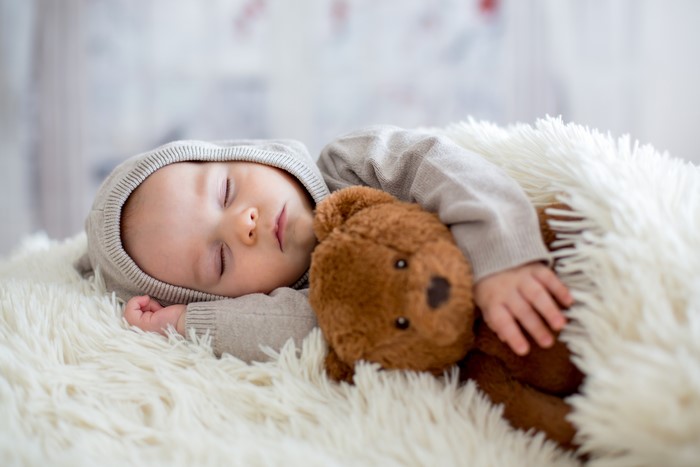 Baby sleeping with teddy bear