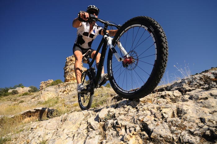 Man riding a bicycle on a rocky mountain trail