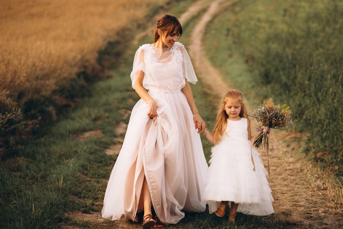 Bride and flower girl walking on a path
