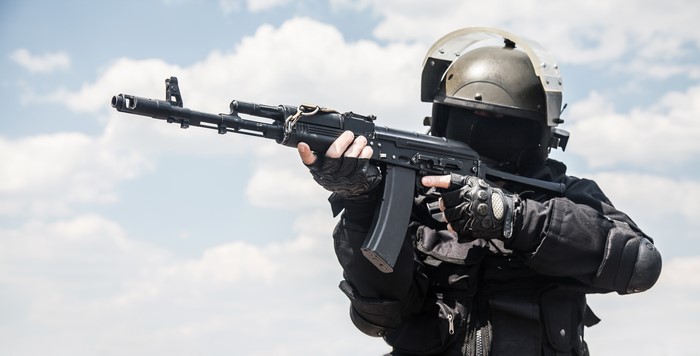 Soldier aiming an assault rifle with a helmet