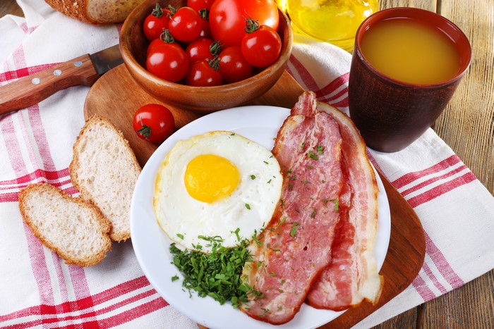 Breakfast with Fried Egg, Bacon, Tomatoes, Bread, and Juice