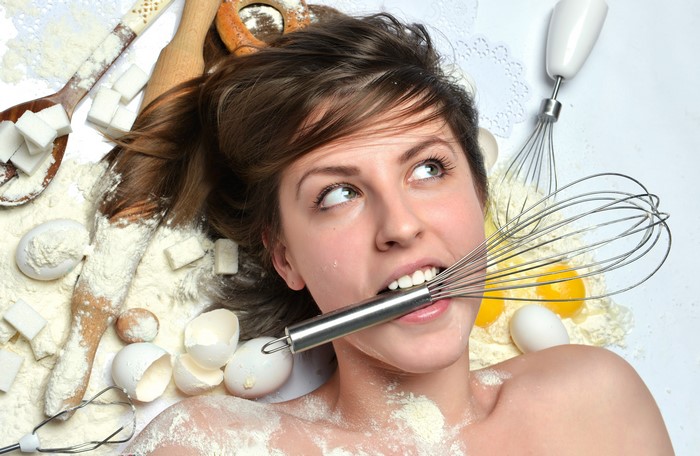 Woman with whisk and baking ingredients