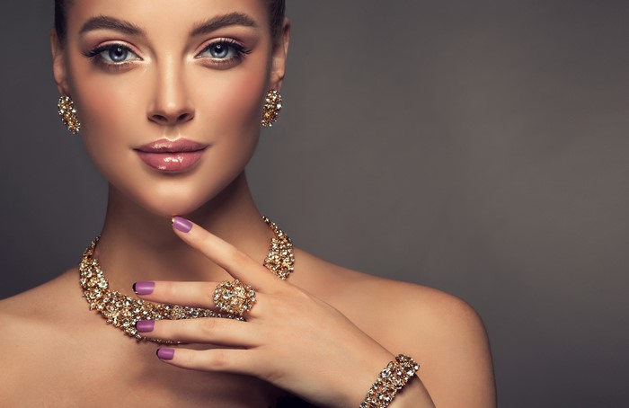 Woman wearing diamond necklace, earrings, ring, and bracelet