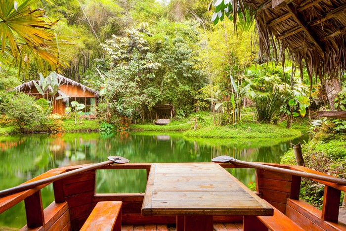 Wooden boat with table on a tropical pond