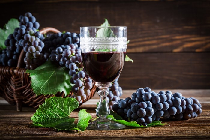 Glass of Red Wine with Grapes in Basket