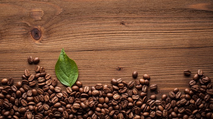 Coffee beans and leaf on wood planks