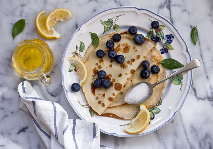 Pancakes with Blueberries, Lemon, and Honey on a Plate