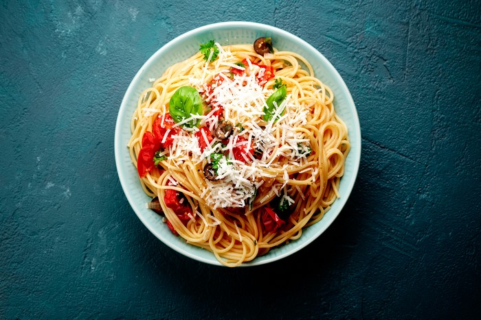 Spaghetti with tomatoes, olives, basil, and cheese