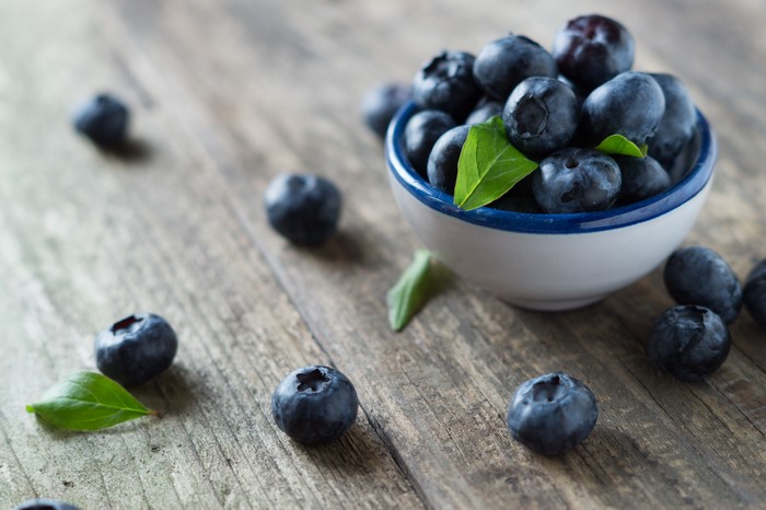 Blueberries in a bowl on wood planks