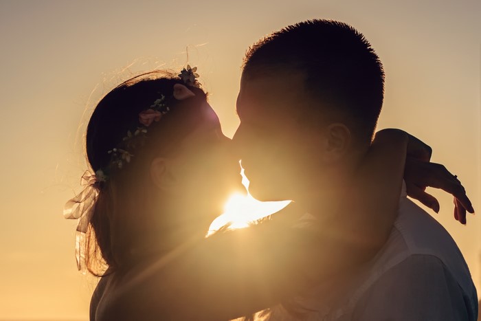 Couple kissing at sunset silhouette