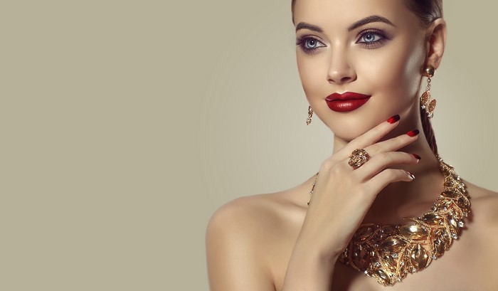 Elegant Woman with Gold Jewelry and Red Makeup