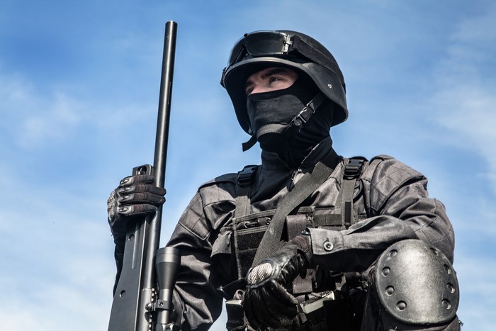 Soldier in tactical gear holding a sniper rifle