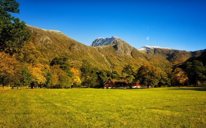 Red house in a mountain valley during autumn