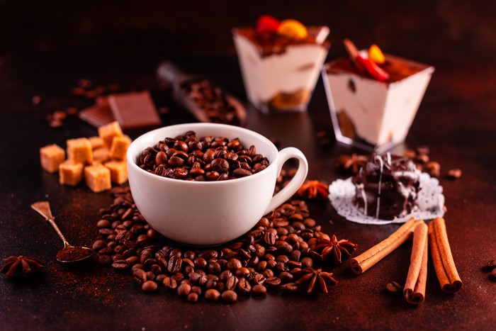 Coffee beans in a cup with desserts and spices