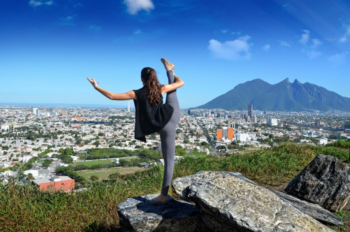 4K Yoga Stretch on Hill Overlooking City