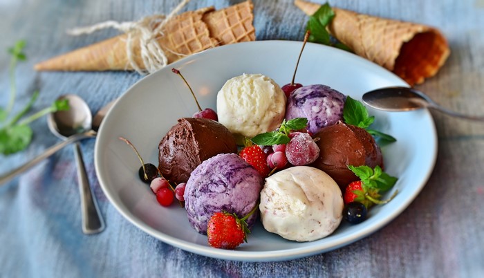 Ice cream scoops with berries and mint on a plate
