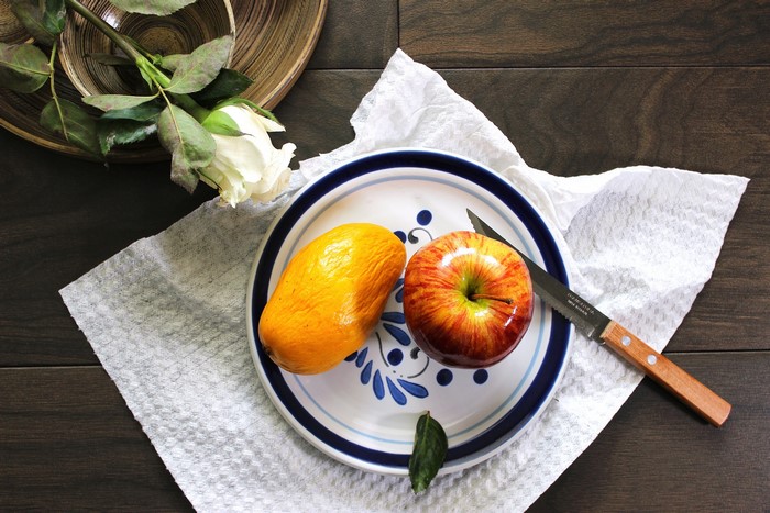 Mango and apple on a plate with a knife and rose