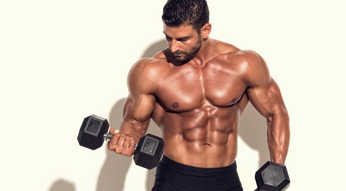 Muscular man lifting dumbbells