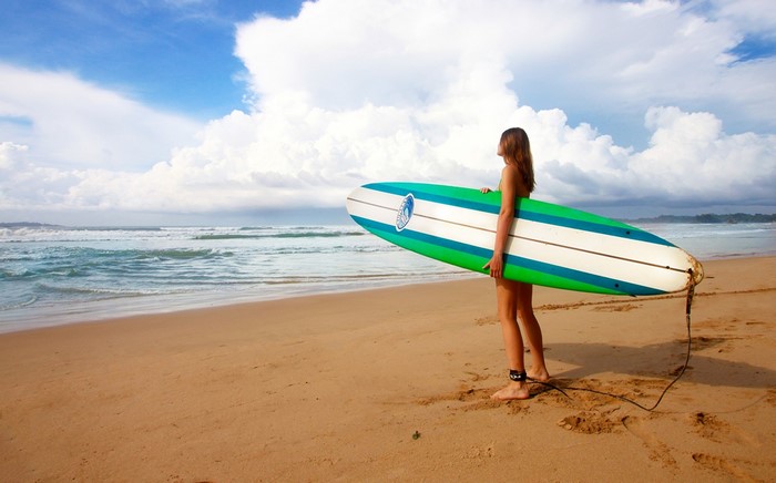 Woman with surfboard on a beach