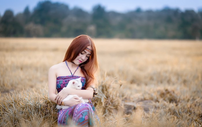 Asian woman with cat in a field