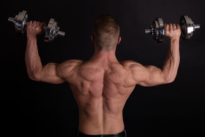 Man with dumbbells on black background