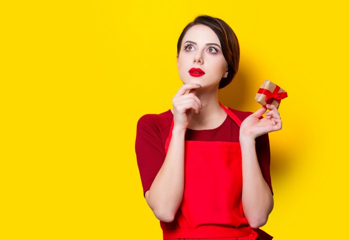 Woman in red apron holding a gift