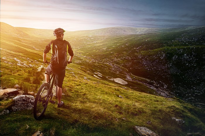 Man on bicycle on a grassy hill