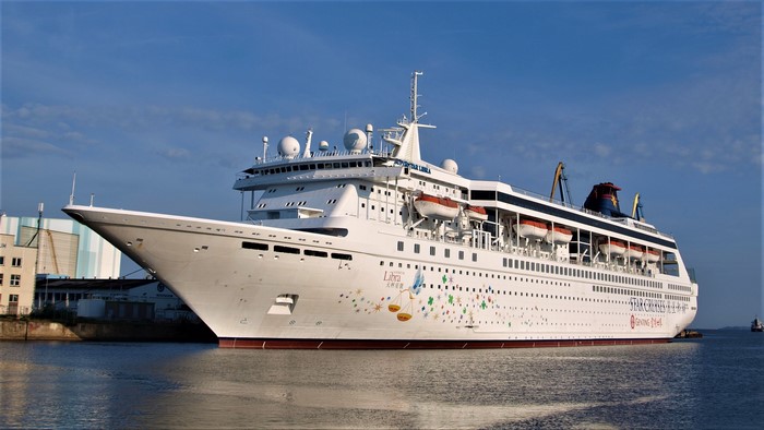 SuperStar Libra cruise liner docked near buildings