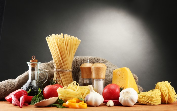 Still-life of pasta, tomatoes, cheese, garlic, and spices