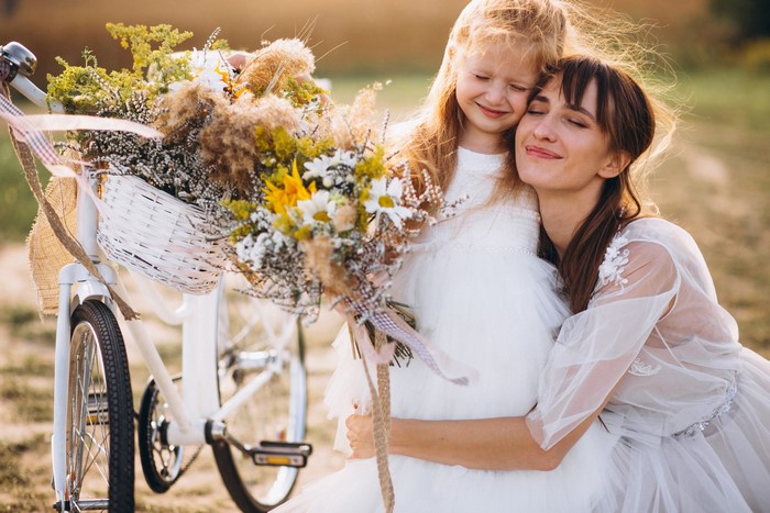 Woman and girl with flowers on a bicycle