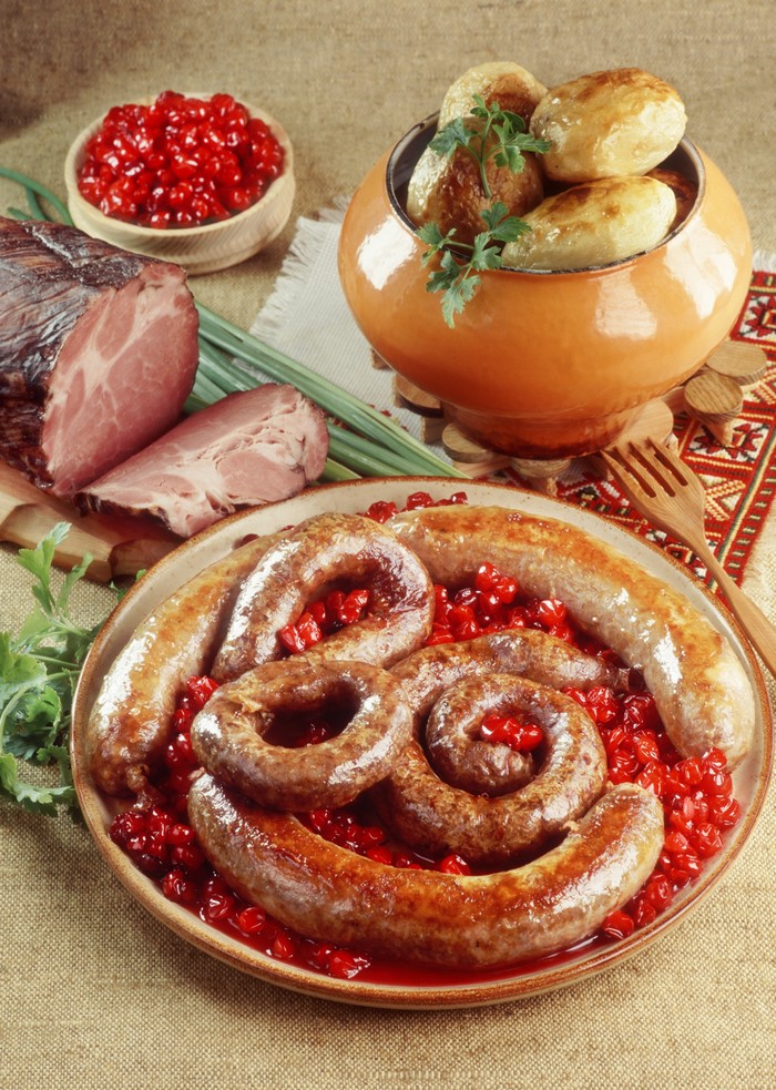 Sausages, ham, and potatoes with red berries