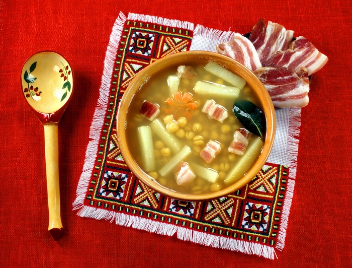 Bowl of pea soup with bacon and spoon