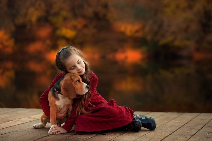 Girl hugging a Beagle dog