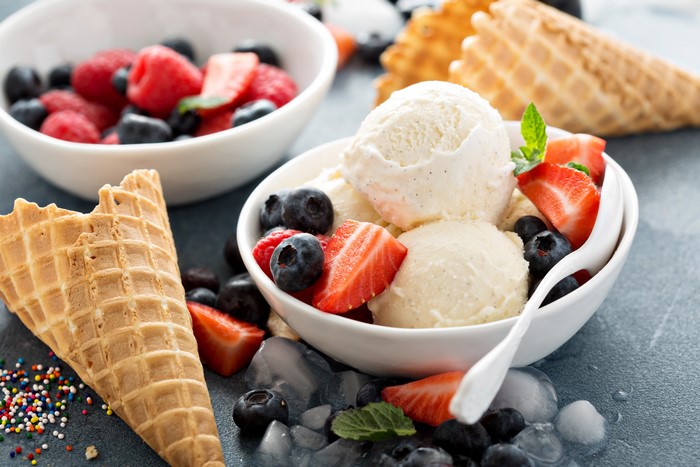 Ice cream with strawberries and blueberries in a bowl with cones