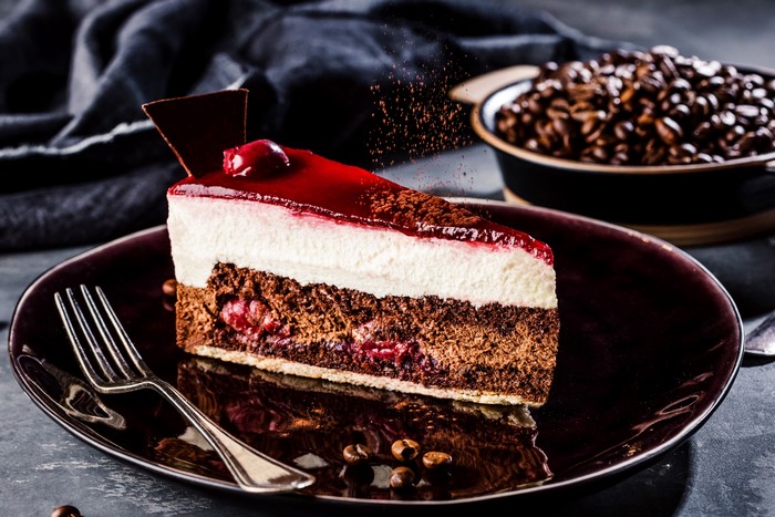 Slice of cherry chocolate cake with coffee beans