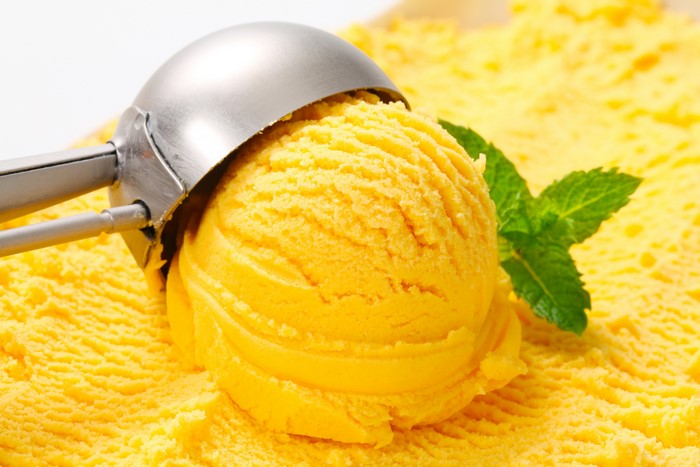 Yellow ice cream scoop with mint leaf