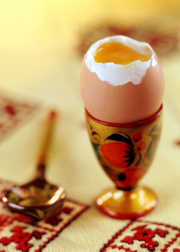 Soft-boiled egg in an ornate egg cup with a spoon