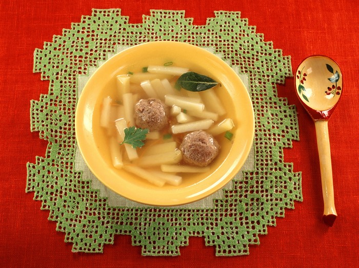 Soup with meatballs and potatoes on a tablecloth