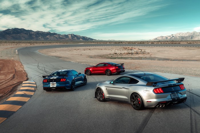 Three Ford Mustang Shelby GT500 cars on a racetrack