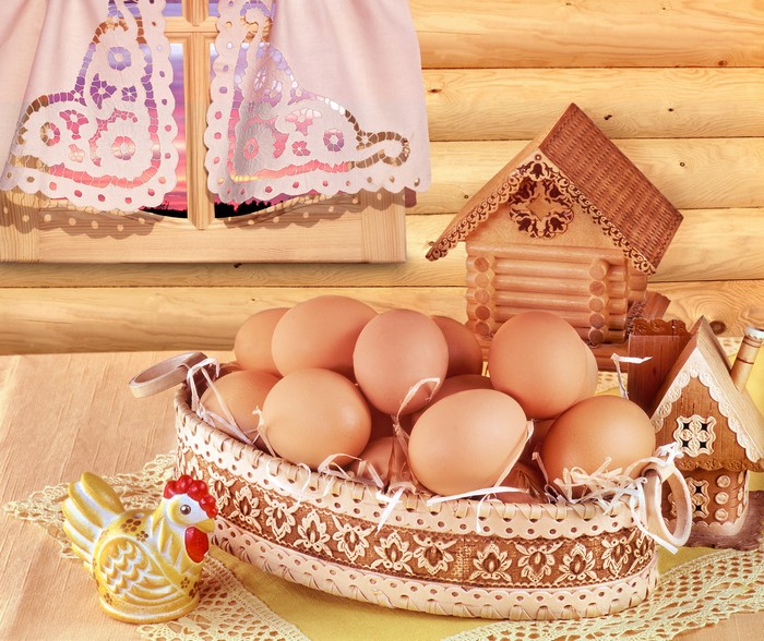 Basket of eggs with wooden houses and chicken figurine