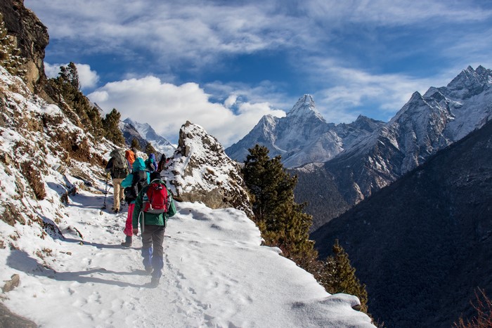 Hikers on a snowy trail in the Himalayas, Nepal