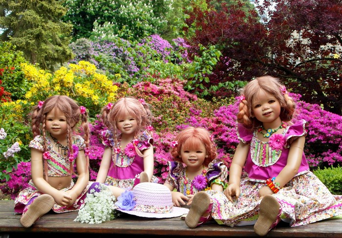 Four dolls in a park with flowers