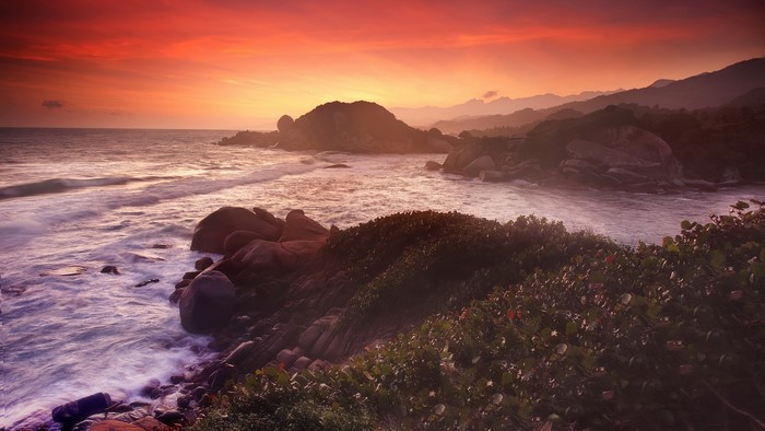 Sunset over a rocky coast with waves